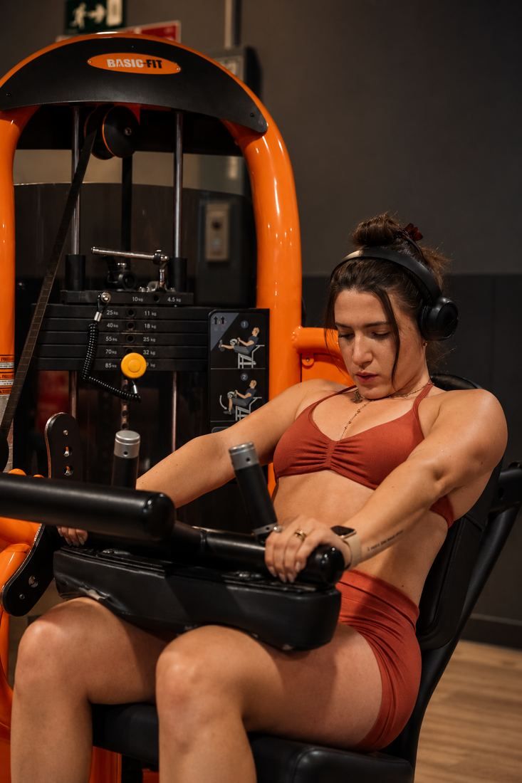 Patrizia entrenando en una máquina de musculación en el gimnasio